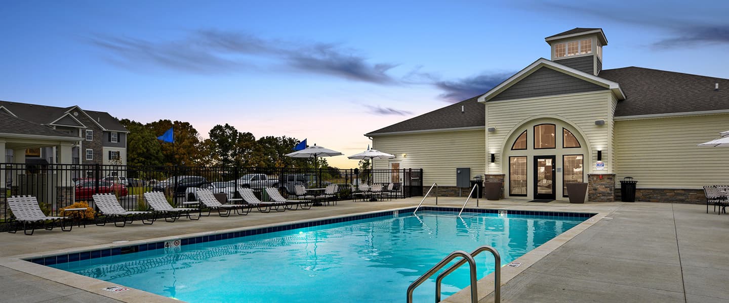 A beautiful pool complete with outdoor seating and umbrellas.