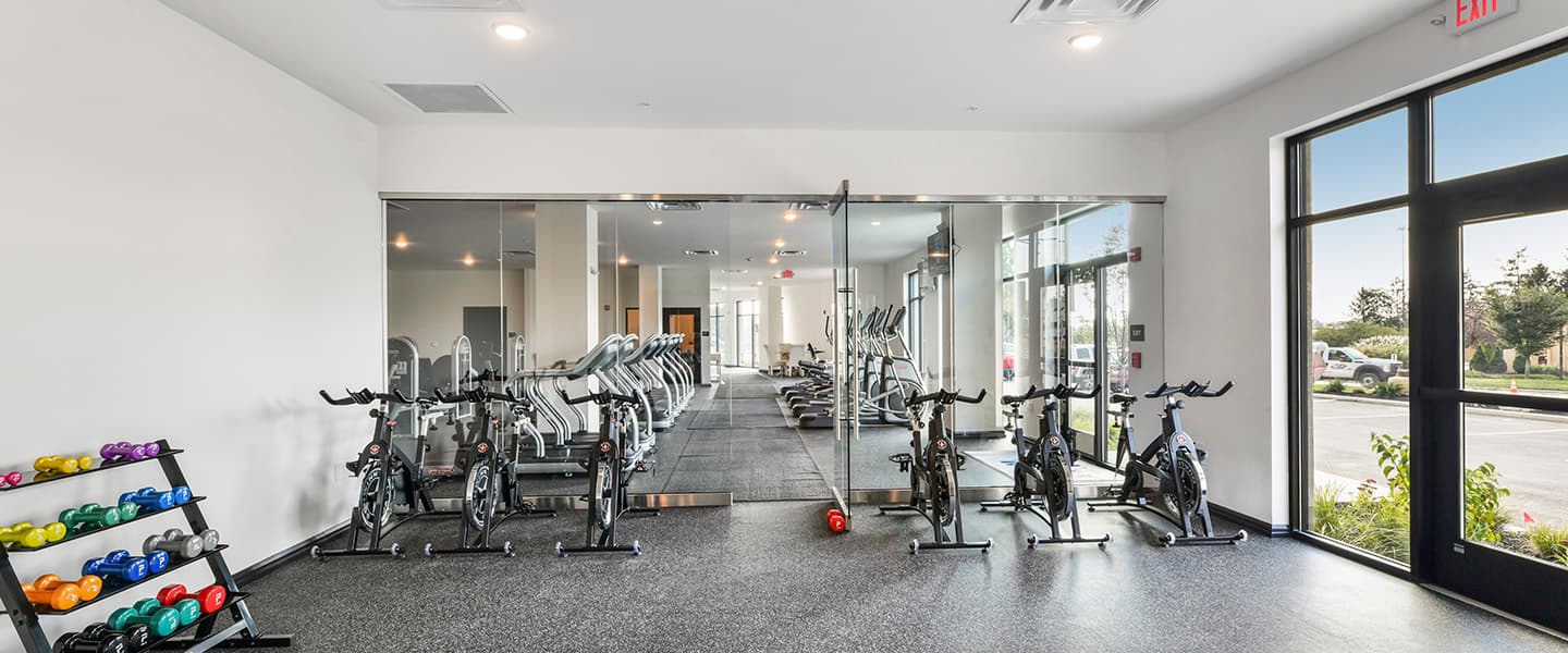 A modern community workout center with exercise equipment and natural light.