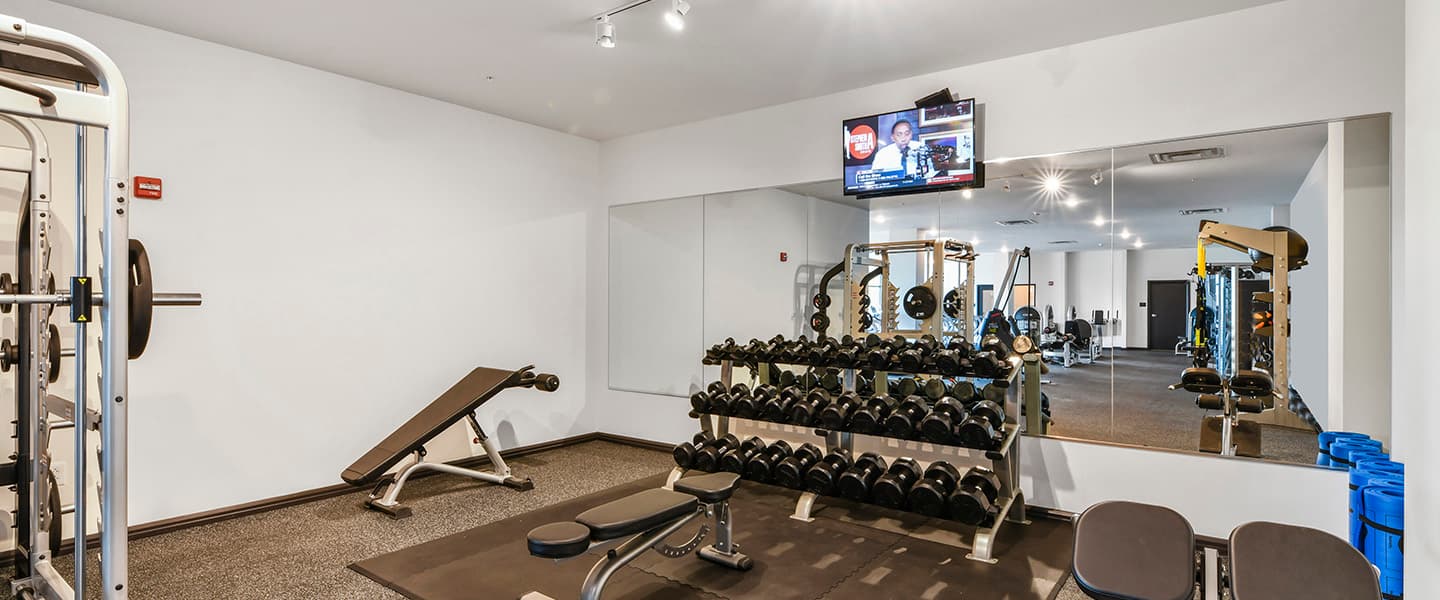 A modern community workout center with exercise equipment and natural light.