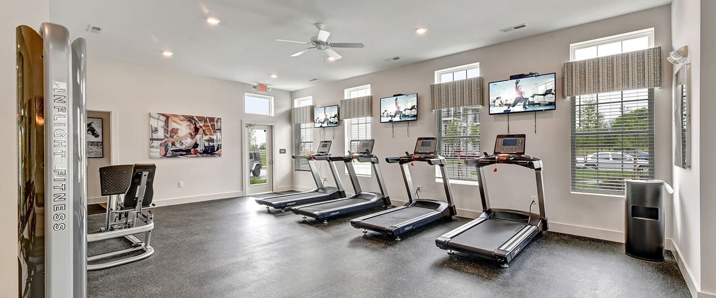 A modern community workout center with exercise equipment and natural light.