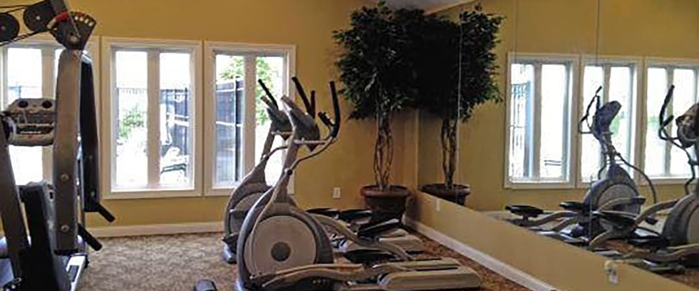 A modern community workout center with exercise equipment and natural light.