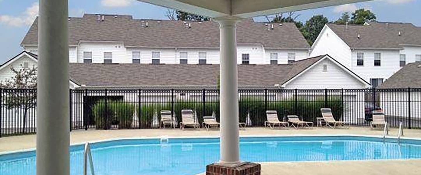 A beautiful pool complete with outdoor seating and umbrellas.