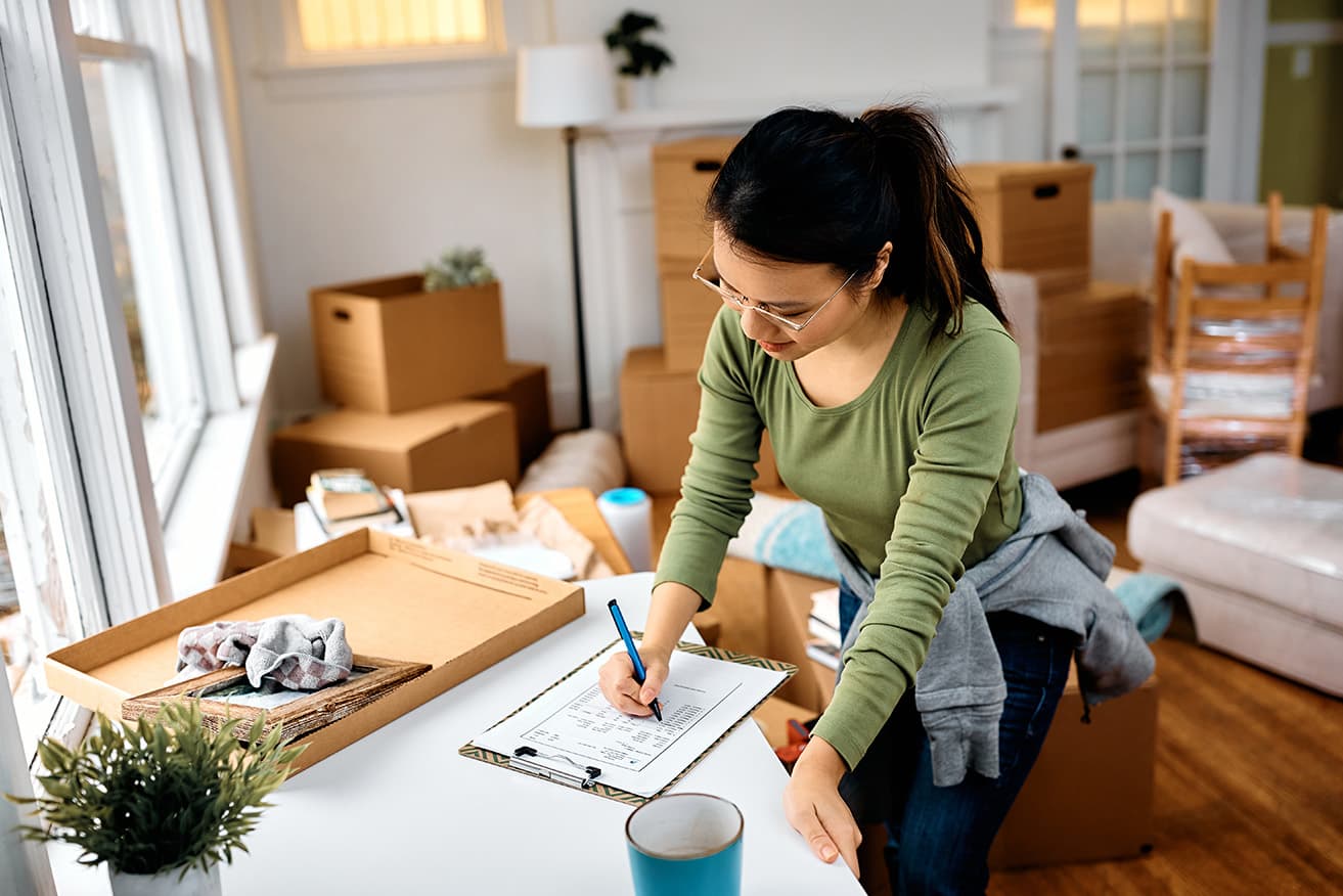 Asian woman going through checklist while before moving out of her apartment.