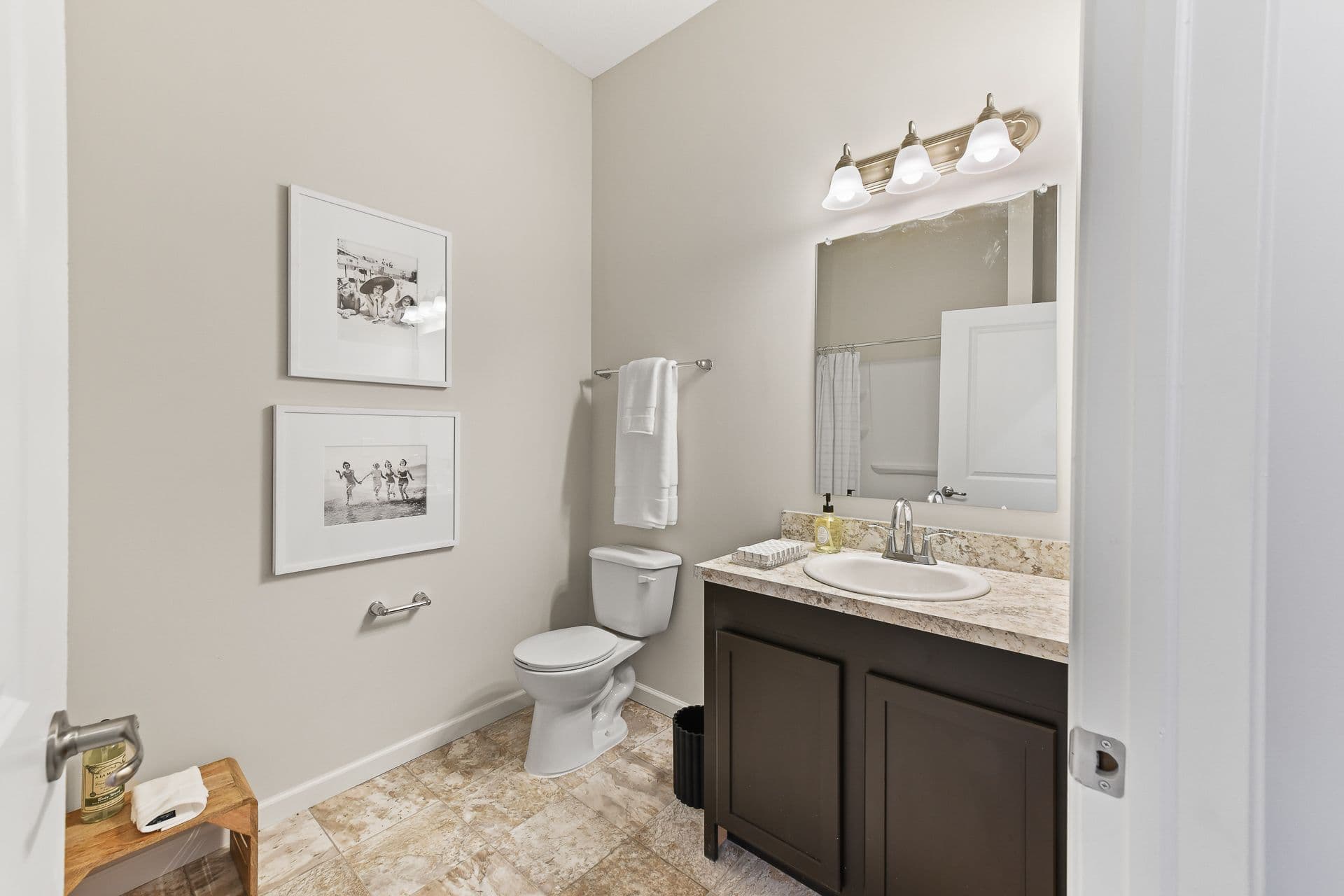 An apartment bathroom with a vanity mirror and sink next to a toilet