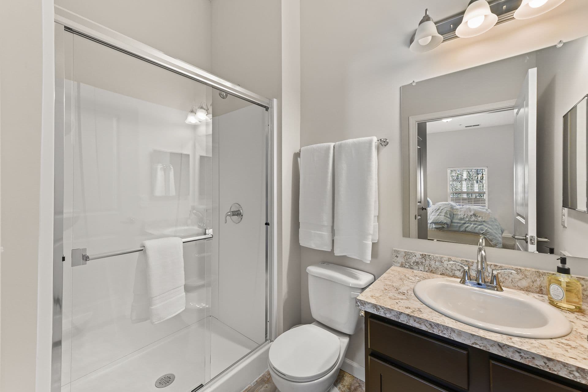 A bathroom with a toilet in between a sink and shower
