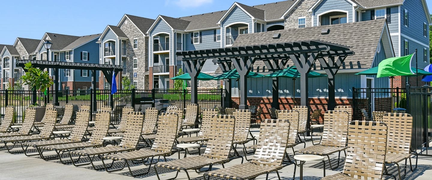 Poolside area featuring numerous chairs for lounging