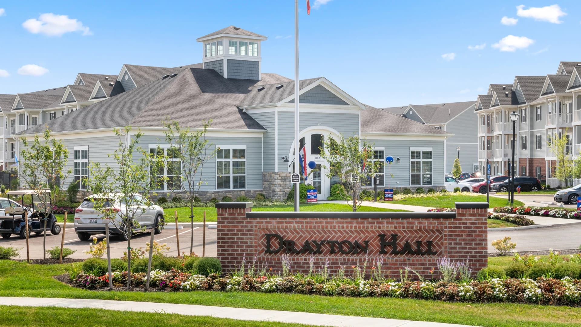 Brick signage for Drayton Hall in Etna Ohio and view of the apartment complex on a sunny day