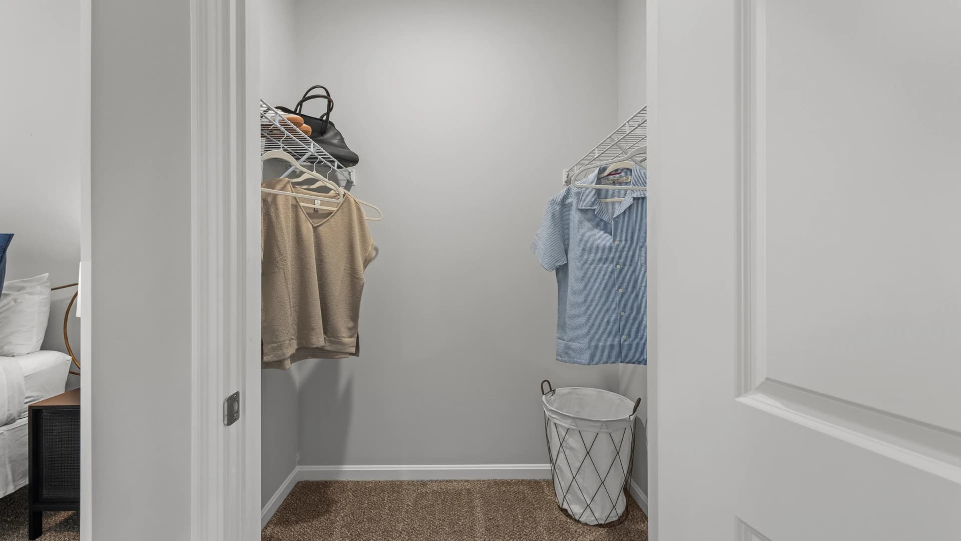 Spacious walk in closet with clothes hanging from hanger in the bedroom of an Etna Ohio apartment unit