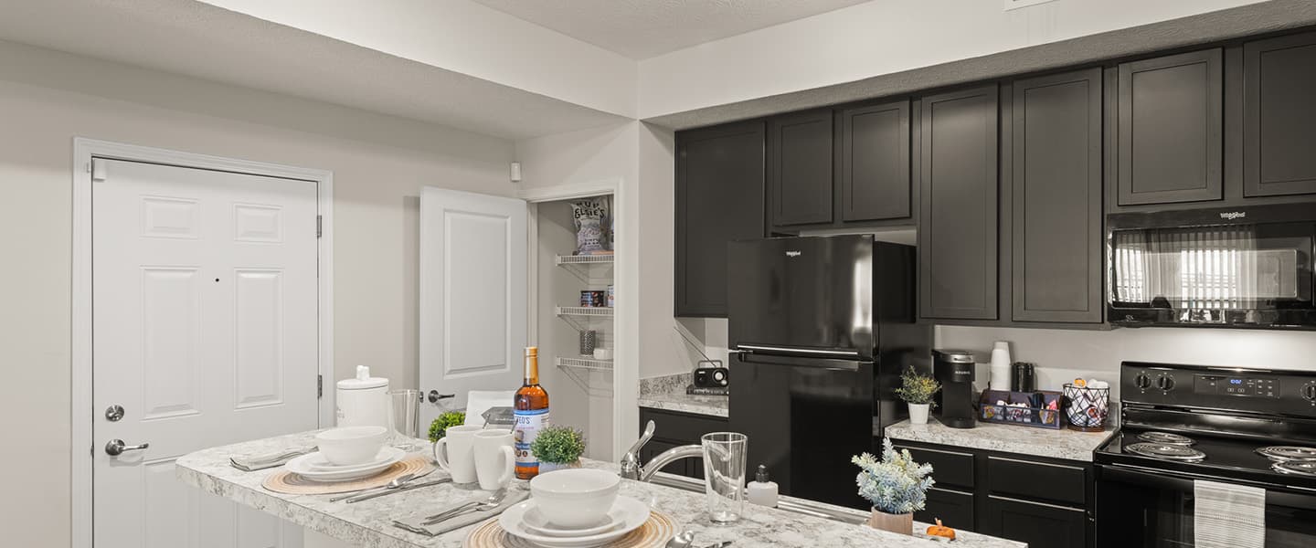 Modern kitchen area with black appliances in a Powell Ohio apartment unit