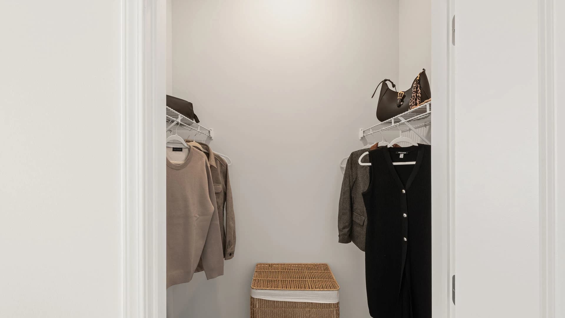 Walk in closet with clothes hanging from hangers in a Grove City apartment unit