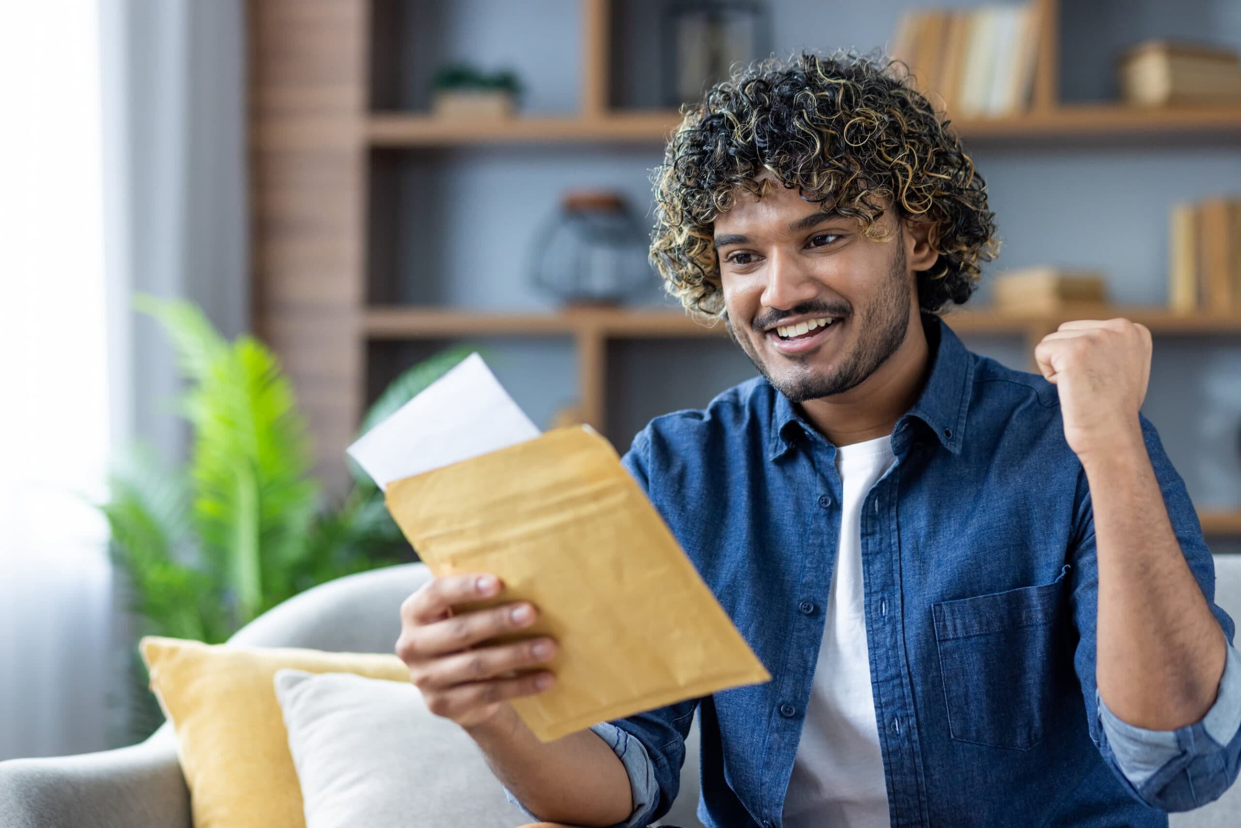 Man reading letter, expressing delight