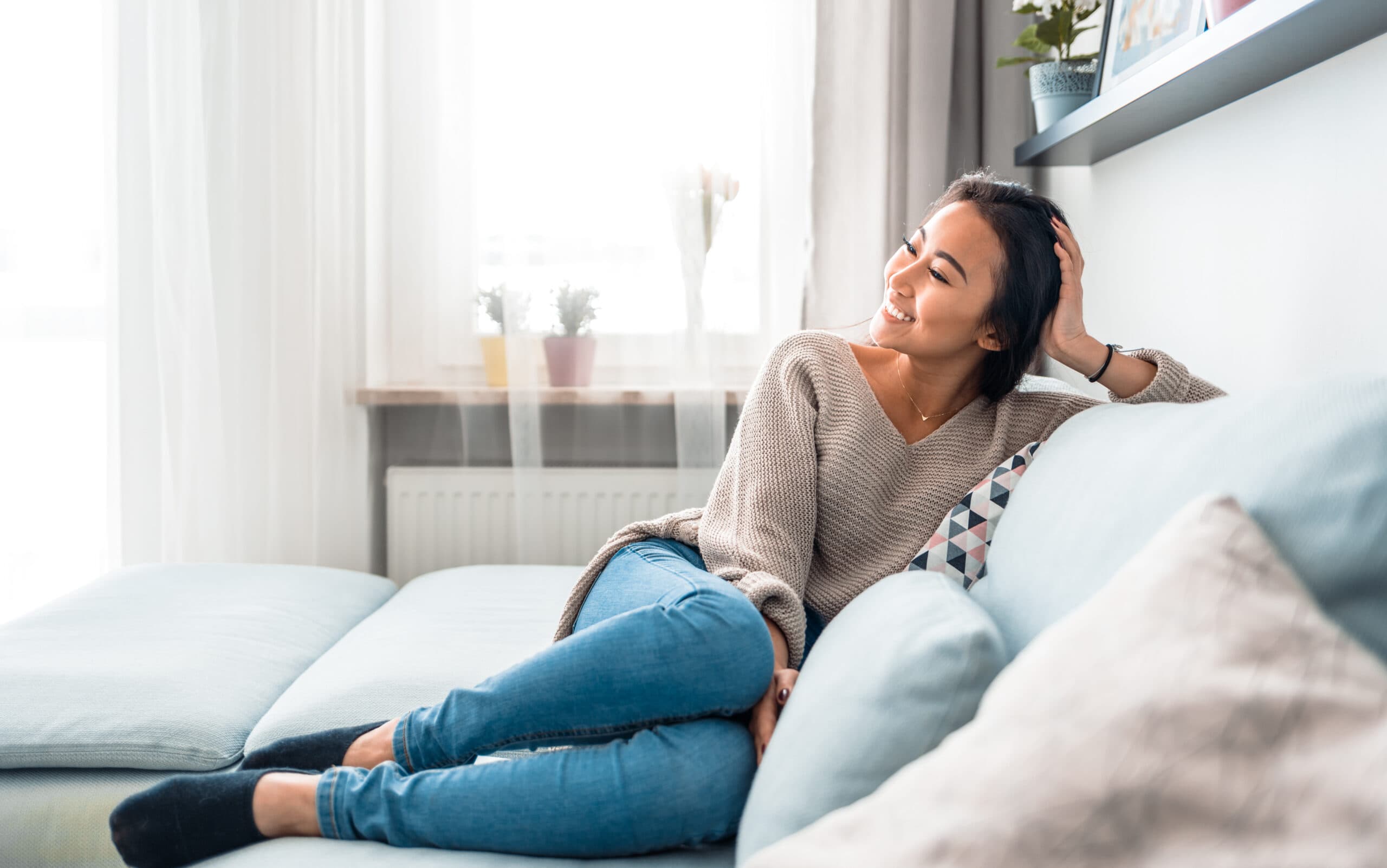 woman sitting on a couch in her apartment