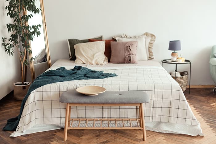 Light bedroom rustic interior with natural materials. Wooden furniture and cotton textiles.