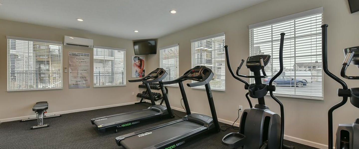 A modern community workout center with exercise equipment and natural light.