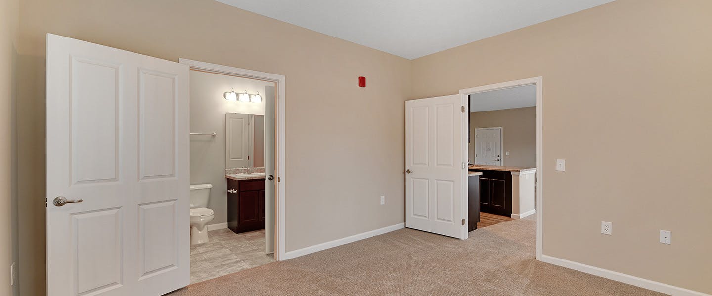 A newly renovated bedroom with access to a master bathroom and living room.