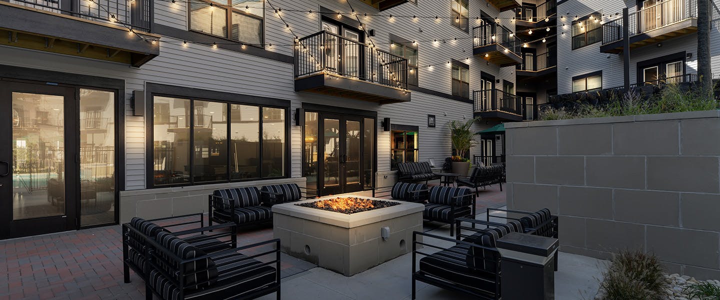A beautiful outdoor seating area with a fireplace and modern decor.