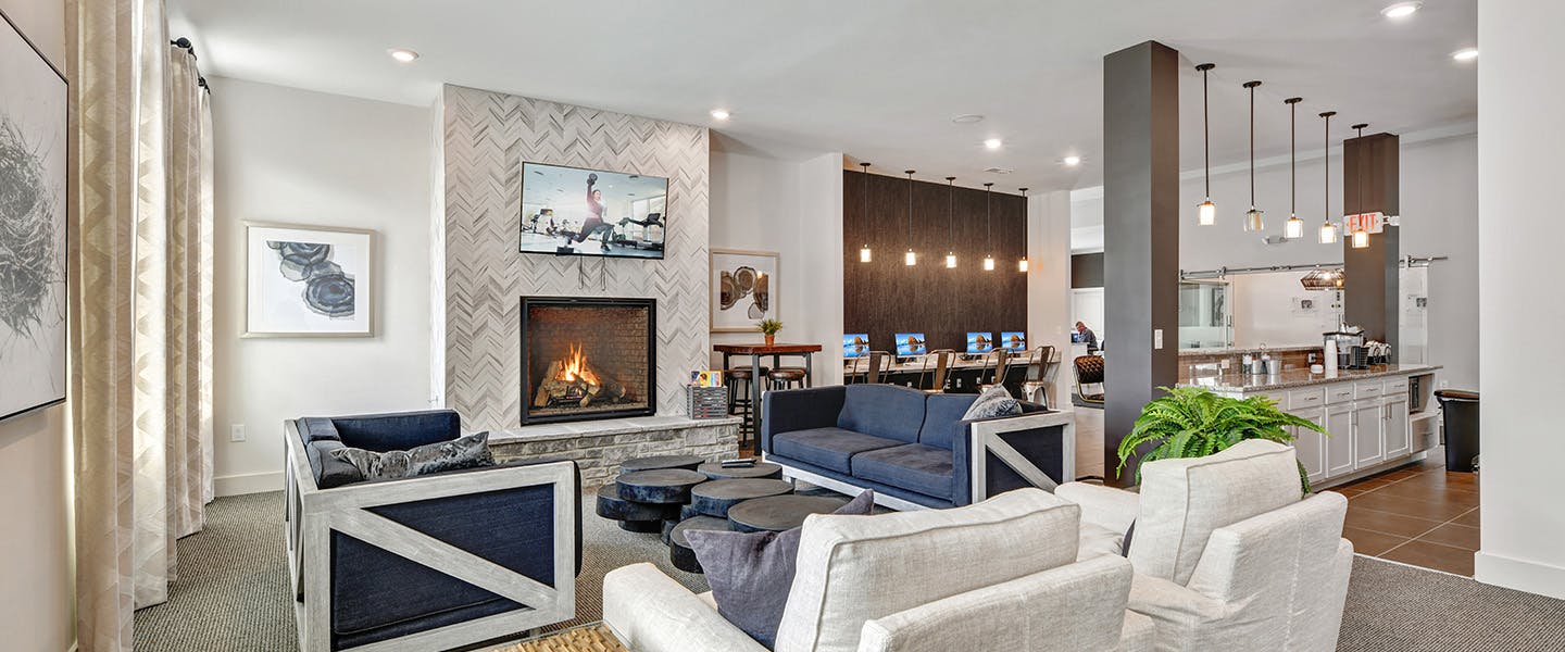 A community space complete with furniture, modern decor and a fireplace.