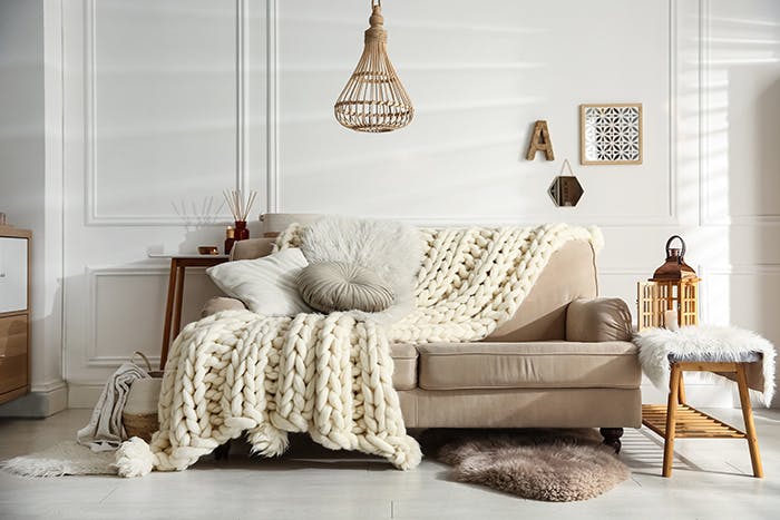 Comfy tan couch with throw blankets and pillow