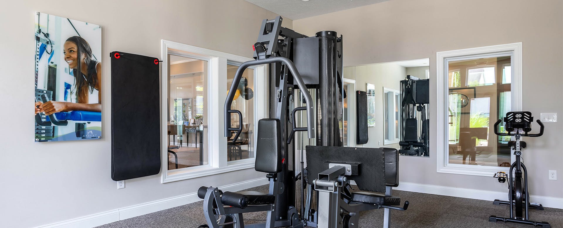A modern community workout center with exercise equipment and natural light.