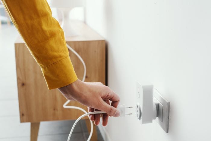 A smart plug devices being plugged into an apartment's wall outlet