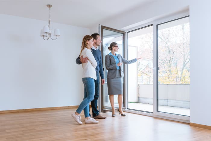 a young couple getting an in-person tour through an apartment they are considering renting